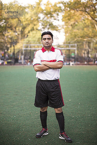 Porträt eines Fußballspielers mit verschränkten Armen auf dem Spielfeld