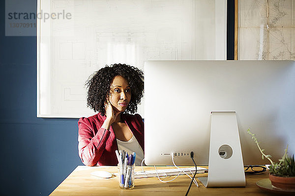 Geschäftsfrau  die im Büro am Desktop-Computer arbeitet