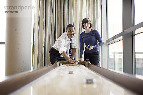 Kollegen spielen Shuffleboard im Amt