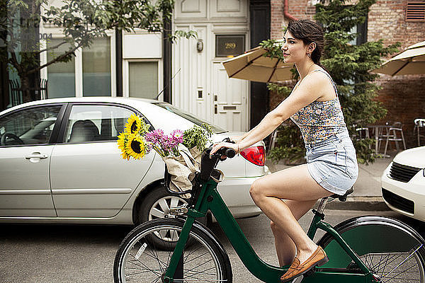 Frau fährt Fahrrad auf der Straße in der Stadt