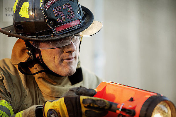 Nahaufnahme eines Feuerwehrmannes mit Taschenlampe