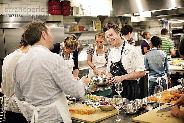 Chefkoch unterrichtet Studenten in der Großküche