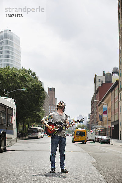 Straßenmusikant spielt Gitarre auf der Straße