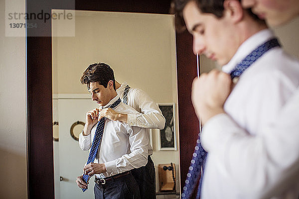 Schwuler Mann hilft seinem Freund beim Anpassen der Krawatte