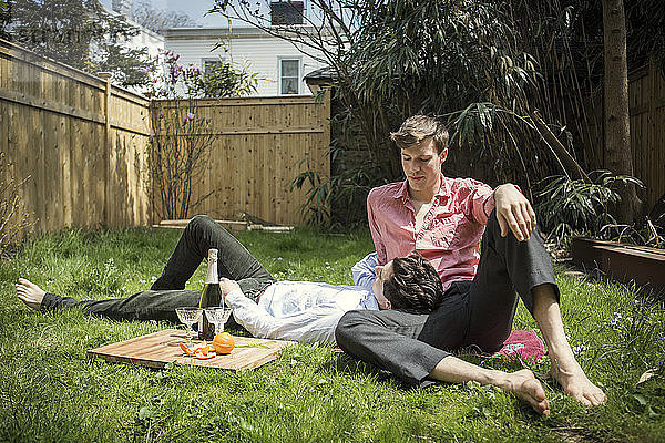 Schwules Paar entspannt sich auf dem Feld im Hinterhof