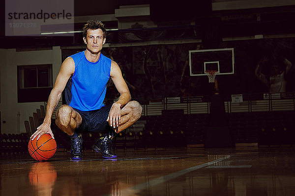 Porträt eines Mannes mit kauerndem Basketball vor Gericht