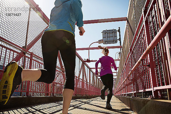 Rückansicht von Freunden  die auf dem Fußweg joggen