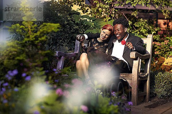 Glückliches Paar sitzt auf Bank im Park