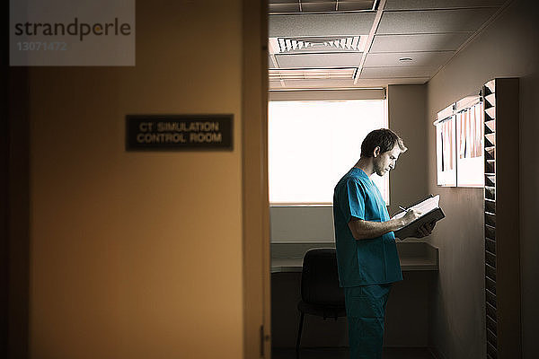 Arzt liest Berichte im Stehen auf der Krankenhausstation