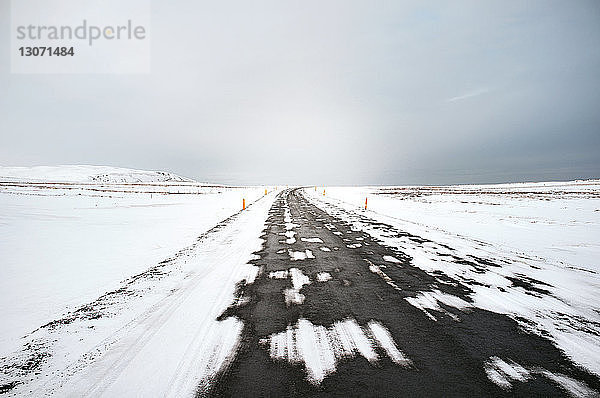 Szenische Ansicht der Straße inmitten eines schneebedeckten Feldes