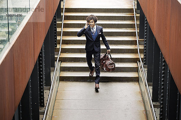 Hochwinkelansicht eines Mannes  der mit einem Smartphone spricht  während er an einer Treppe steht