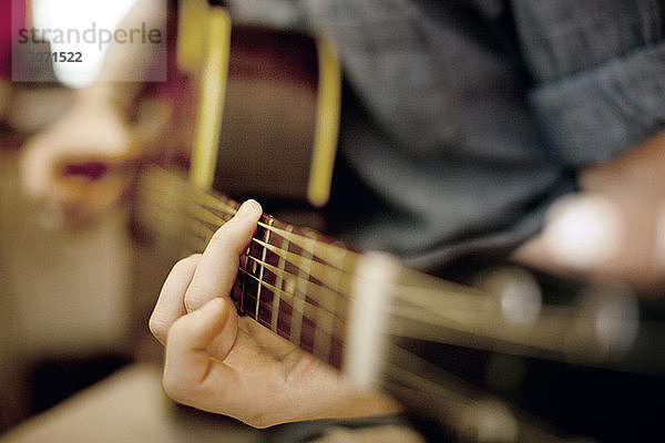 Mittelteil eines Gitarre spielenden Mannes