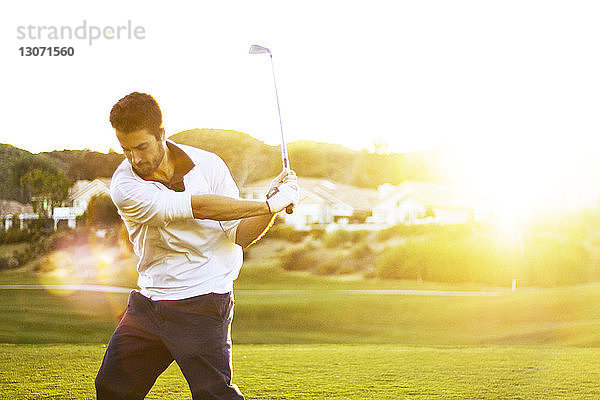 Selbstbewusster Mann spielt Golf auf dem Platz