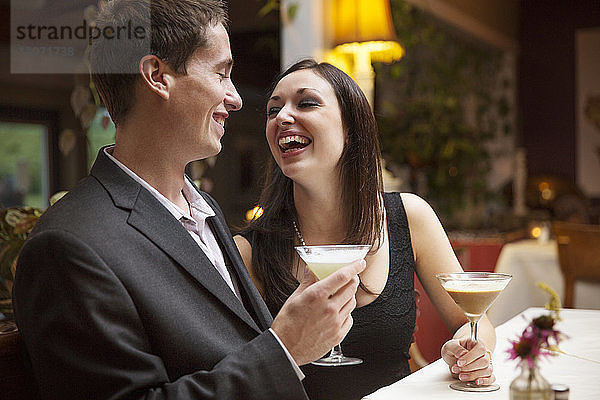 Glückliches Paar beim Cocktail im Restaurant
