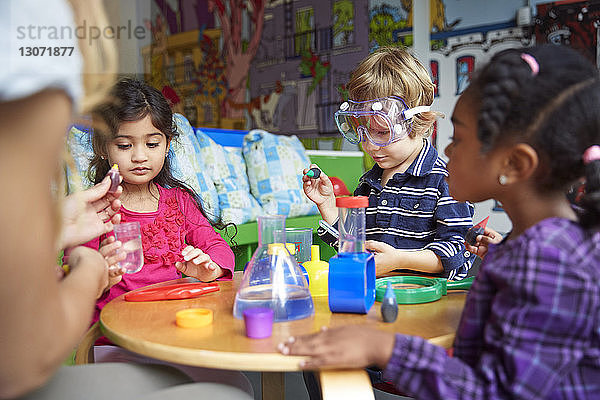 Kinder machen wissenschaftliche Experimente am Tisch in der Vorschule