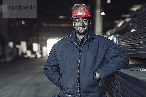 Porträt eines lächelnden Arbeiters in einem Fabriklager