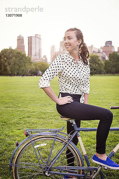 Frau schaut weg  während sie mit dem Fahrrad im Central Park steht