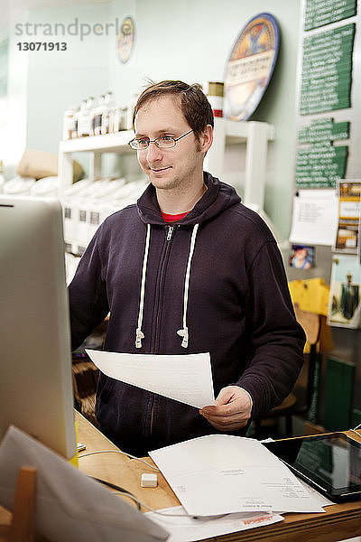 Mann arbeitet am Desktop-Computer in der Werkstatt