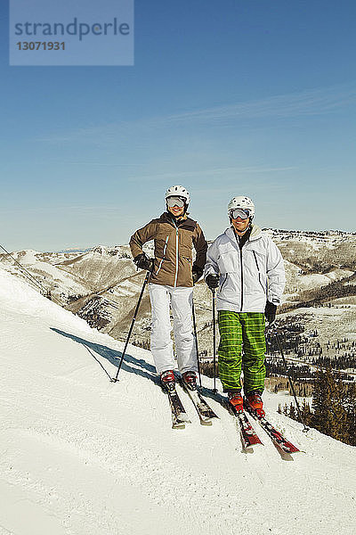 Porträt von Skifahrern auf schneebedecktem Feld stehend