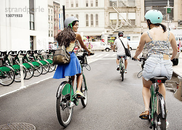 Freunde fahren Fahrrad auf der Straße in der Stadt