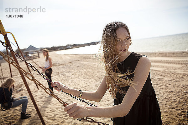 Freunde genießen die Schaukel am Strand