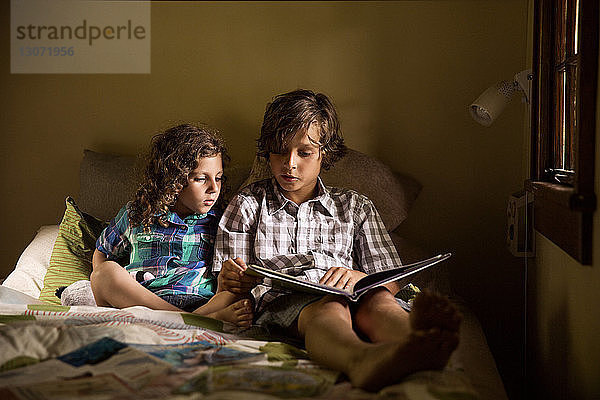 Kinder  die in der Kabine auf dem Bett sitzend ein Buch lesen