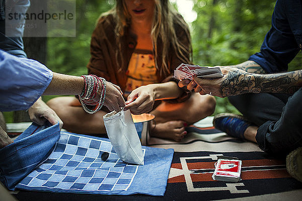 Freunde spielen Kartenspiel  während sie auf der Veranda sitzen