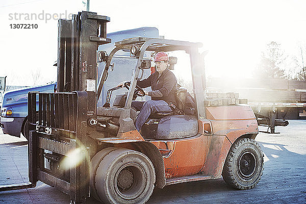 Arbeiter fährt Gabelstapler im Lager