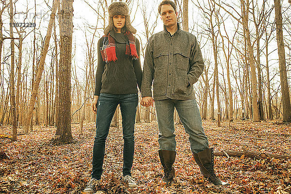 Porträt eines im Wald stehenden Paares  das sich an den Händen hält