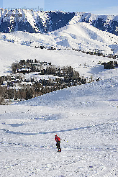 Fernsicht einer Frau beim Skifahren auf schneebedecktem Feld