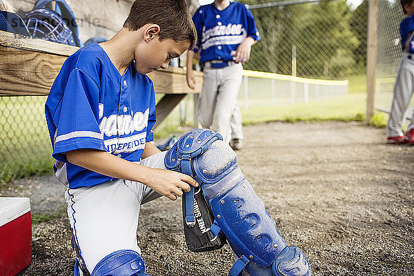 Junge trägt Baseball-Polster auf Unterstand