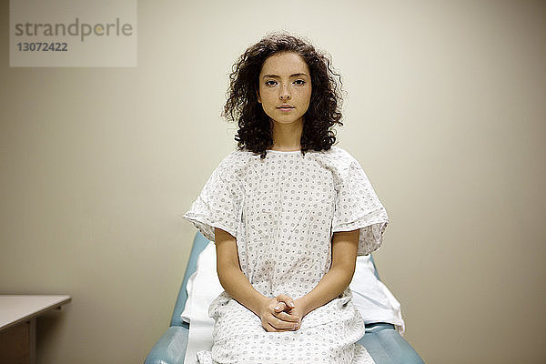 Porträt einer Frau  die im Krankenhaus auf einem Bett sitzt