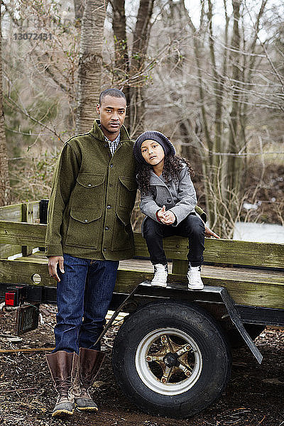 Porträt einer Tochter  die mit ihrem Vater auf einem Fahrzeug sitzt