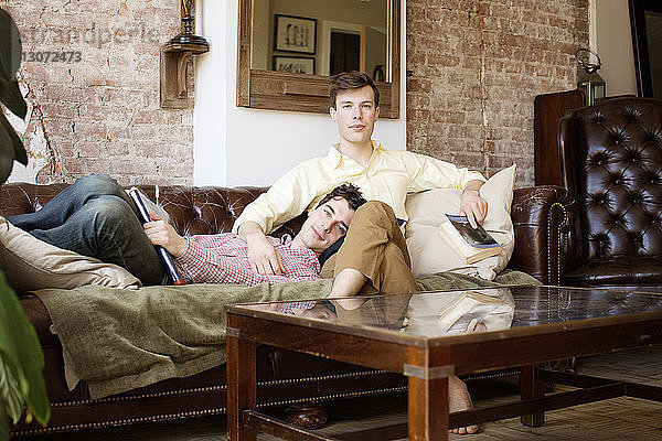 Porträt eines schwulen Paares beim Entspannen auf dem Sofa