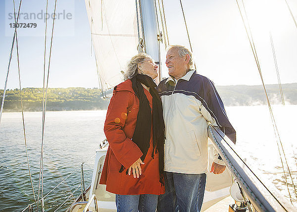 Glückliches älteres Ehepaar  das im Sommer auf einer Yacht auf See steht