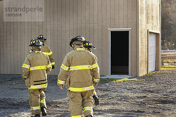 Rückansicht der Feuerwehrleute gegen Haus