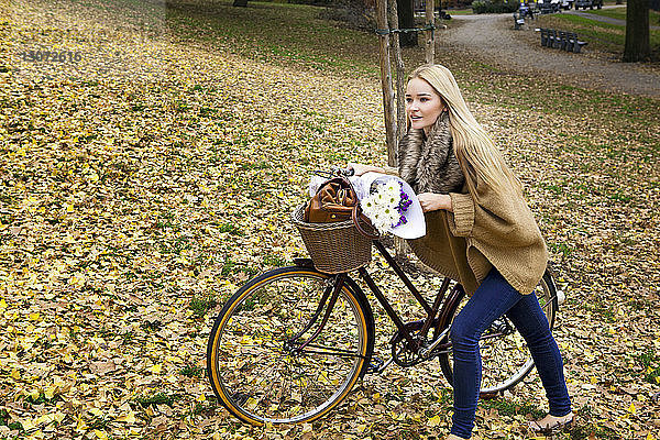 Frau mit Fahrrad auf dem Feld