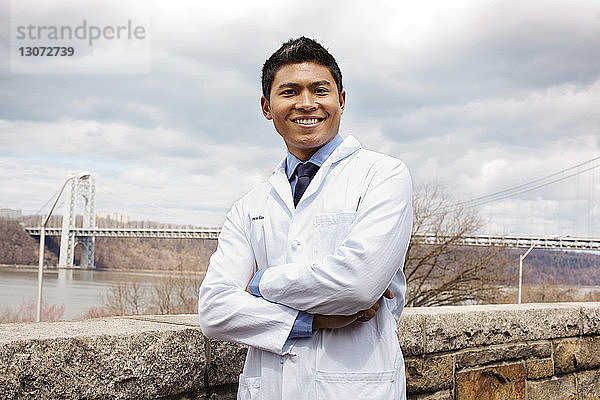 Porträt eines glücklichen Arztes an der Brücke stehend