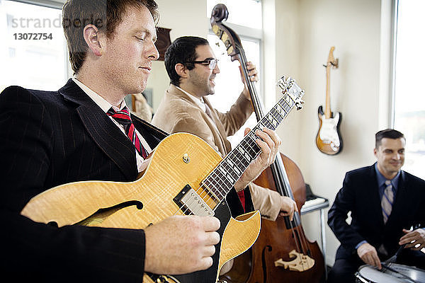 Männer spielen Musikinstrumente im Studio