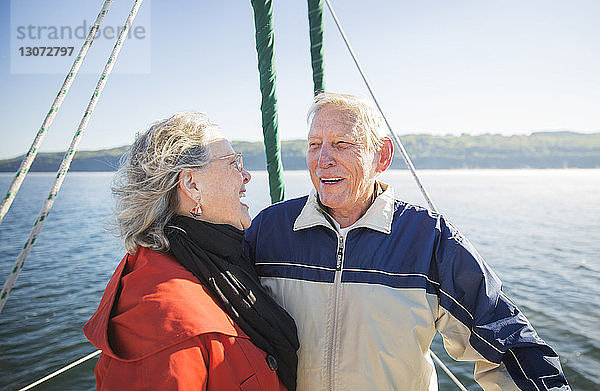 Fröhliche ältere Frau steht mit Mann in Jacht auf See