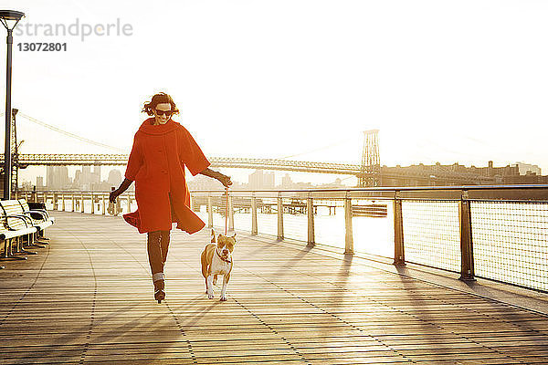 Frau mit Hund rennt auf Promenade gegen Williamsburg Bridge