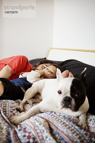 Porträt eines schlafenden Mannes mit Tochter und Hund im Bett