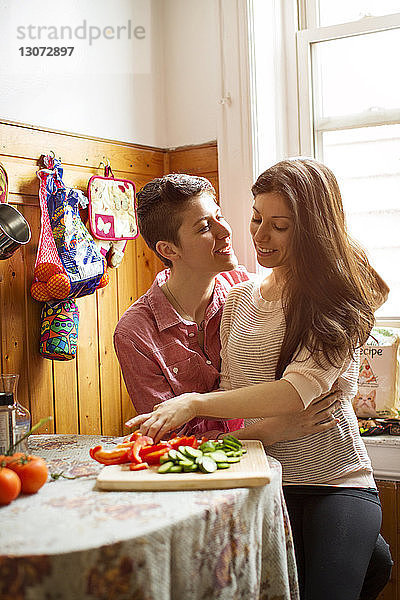 Zärtliches lesbisches Paar  das in der Küche Essen zubereitet