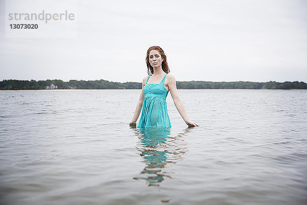 Porträt einer Frau  die im Meer gegen den Himmel steht