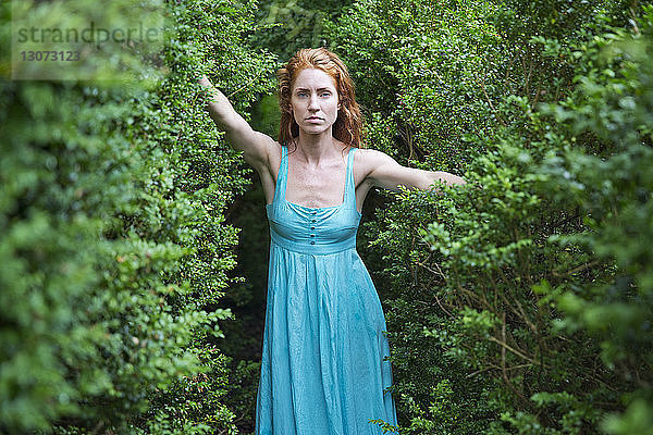 Porträt einer ernsten Frau im Wald stehend