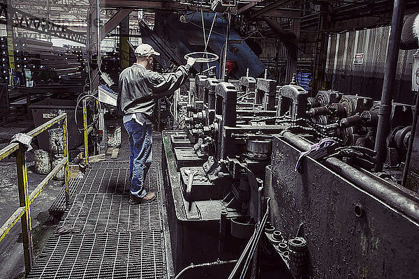 Mann untersucht Maschinen in Fabrik