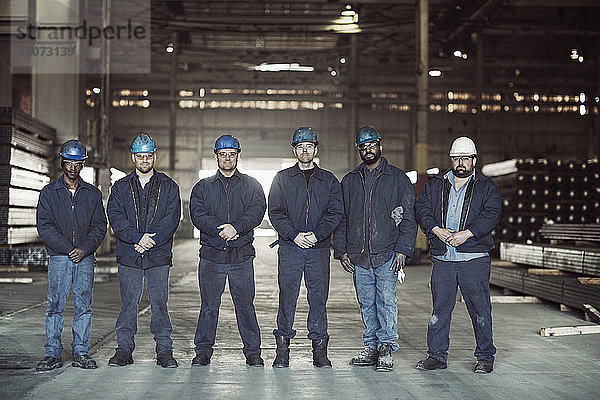 Porträt von selbstbewussten Arbeitern im Fabriklager