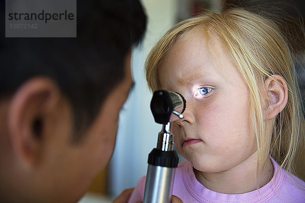 Arzt prüft das Auge des Mädchens