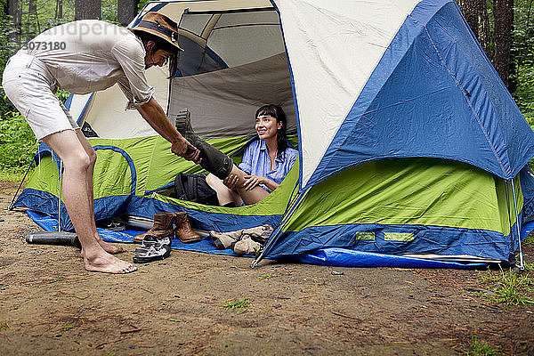 Mann entfernt den Stiefel der Frau auf dem Campingplatz