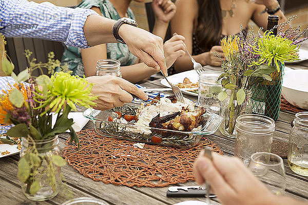 Ausgeschnittenes Bild von Freunden  die am Tisch essen
